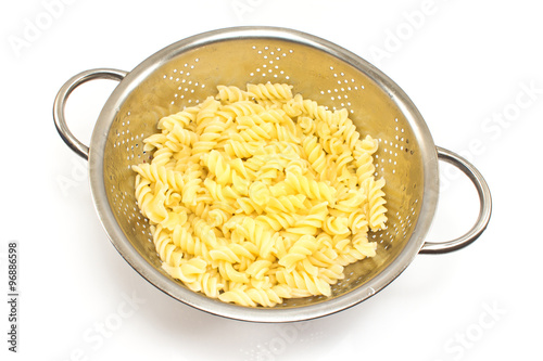 Fresh cooked fusilli pasta in strainer isolated on white