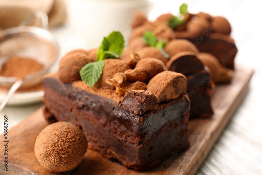 A piece of chocolate cake with walnut and mint on the table, close-up A piece of chocolate cake with walnut and mint on the table, close-up