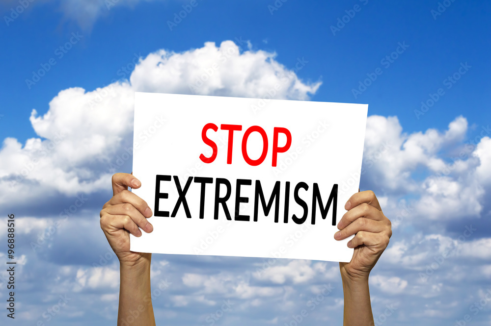 STOP EXTREMISM card in hand against blue sky with clouds. STOP EXTREMISM card in hand against blue sky with clouds.