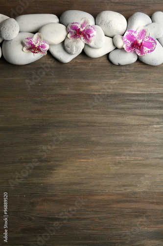 Spa stones and orchid on wooden background