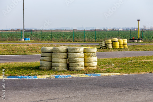 Group of old yellow painted tires used for protection on a racing track