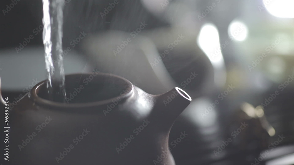 The action of brewing Chinese tea. Water pouring into clay teapot. Asian traditional tea ceremony. Ancient customs of leisure.