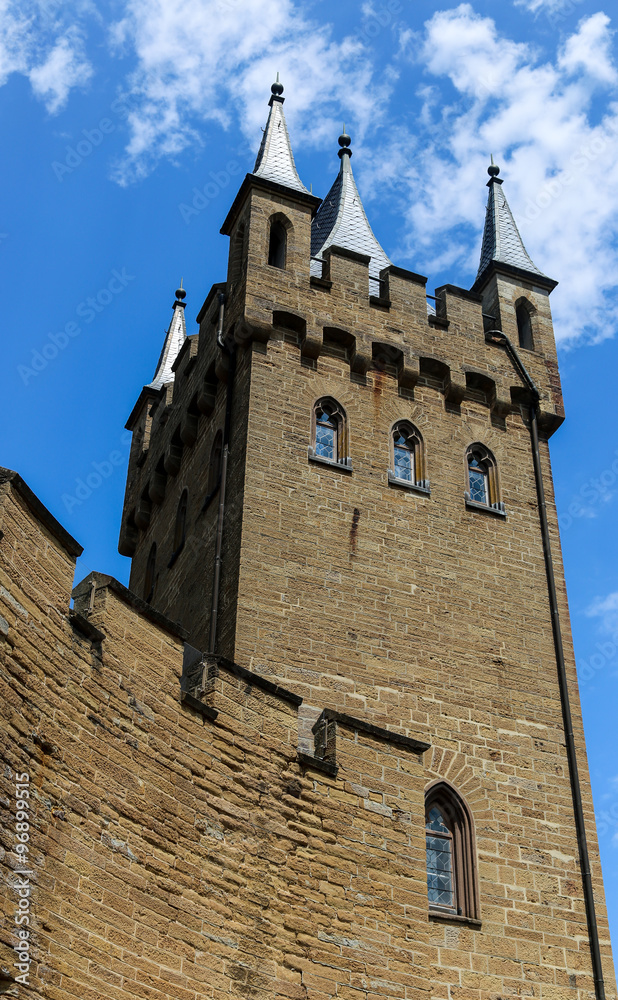 Castle tower walls with windows and blue sky.