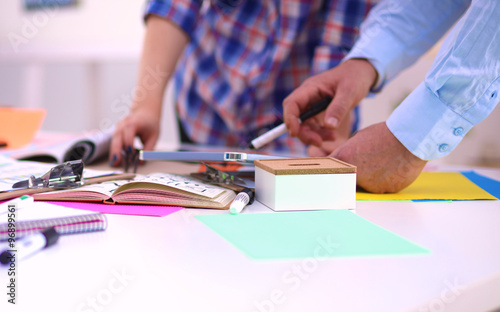 Close-up of three young creative designers working on project together. Team work