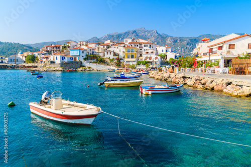 Fishing boats in Kokkari bay with colourful houses in background, Samos island, Greece
