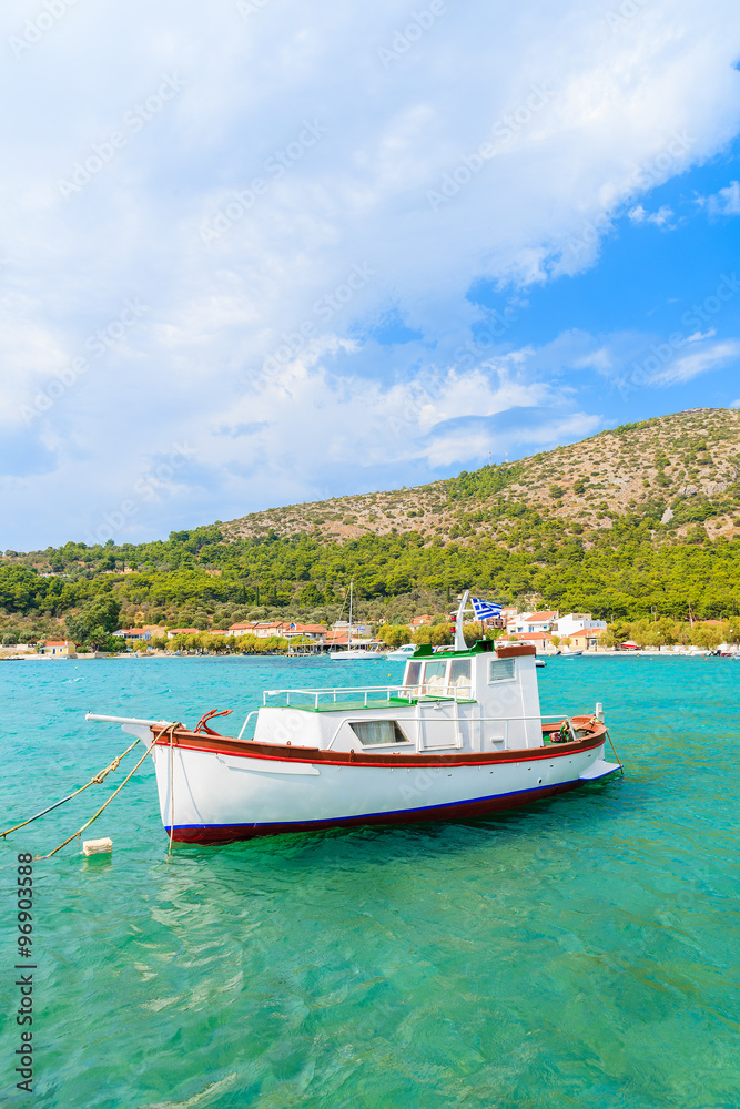 Traditional Greek fishing boat on turquoise sea water in Posidonio bay, Samos island, Greece