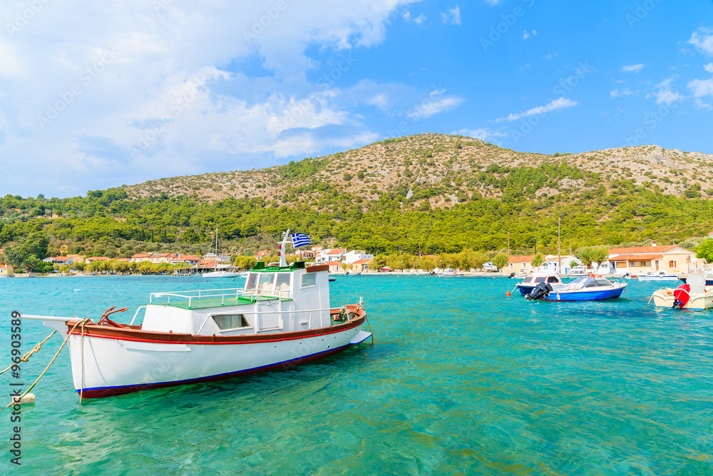 Traditional Greek fishing boat on turquoise sea water in Posidonio bay, Samos island, Greece