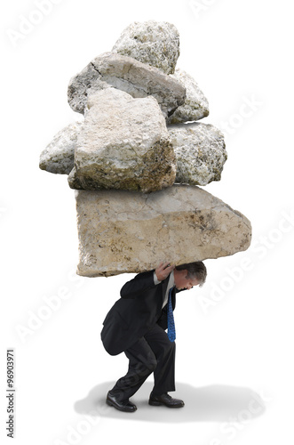 Business man under a huge pile of rocks who is feeling the pressure and stress of this big challenge.
