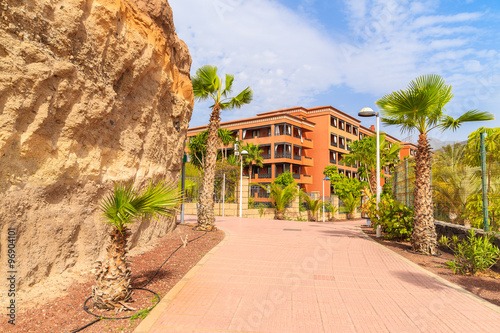 Tropical promenade with hotel buildings in background in Costa Adeje town, Tenerife, Canary Islands, Spain