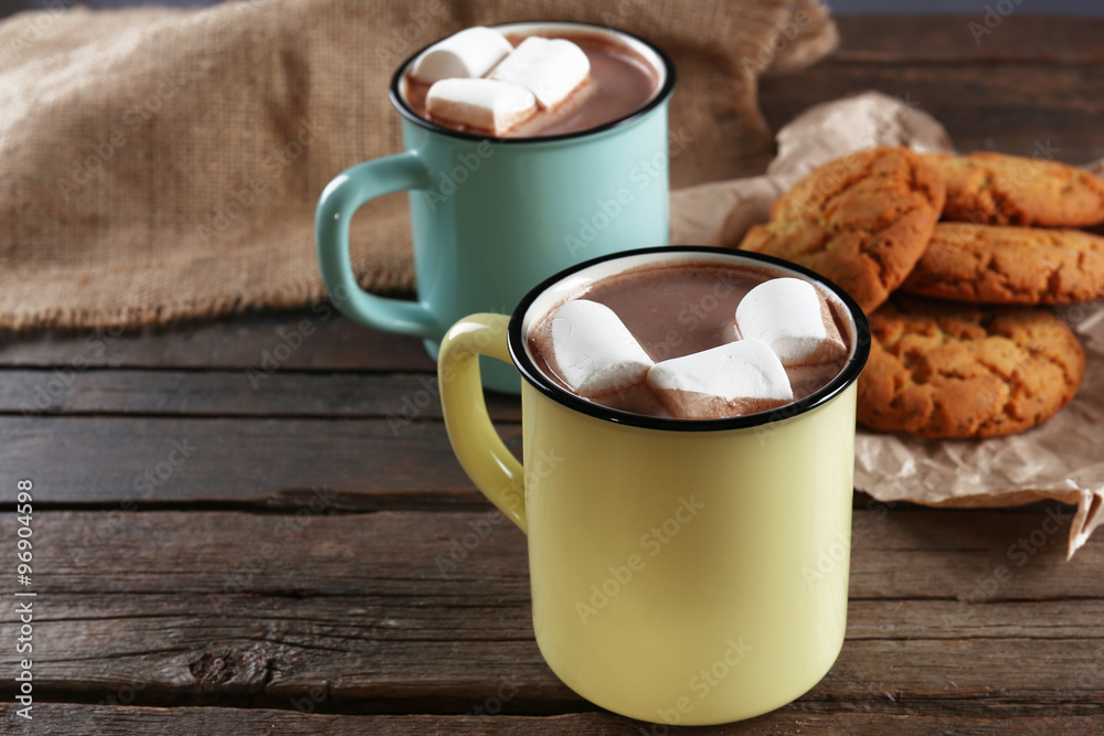 Tasty cocoa and marshmallow in metal old-fashioned mugs on the table Tasty cocoa and marshmallow in metal old-fashioned mugs on the table