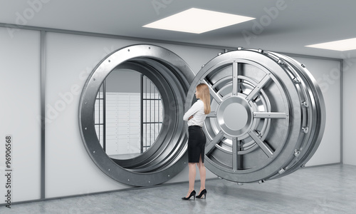 young lady standing in front of a big unlocked round metal safe
