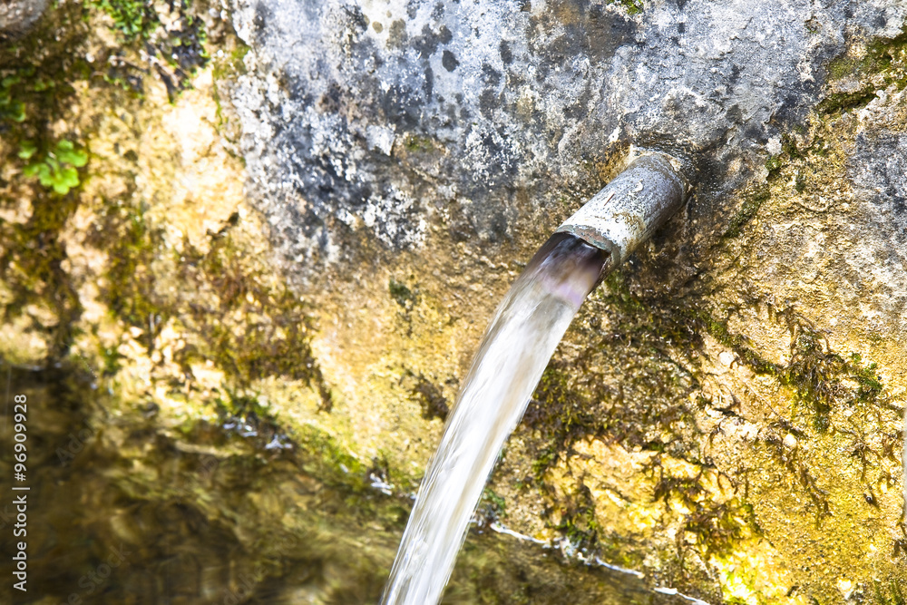 Source of drinking water comes from a stone wall - image with copy space Source of drinking water comes from a stone wall - image with copy space