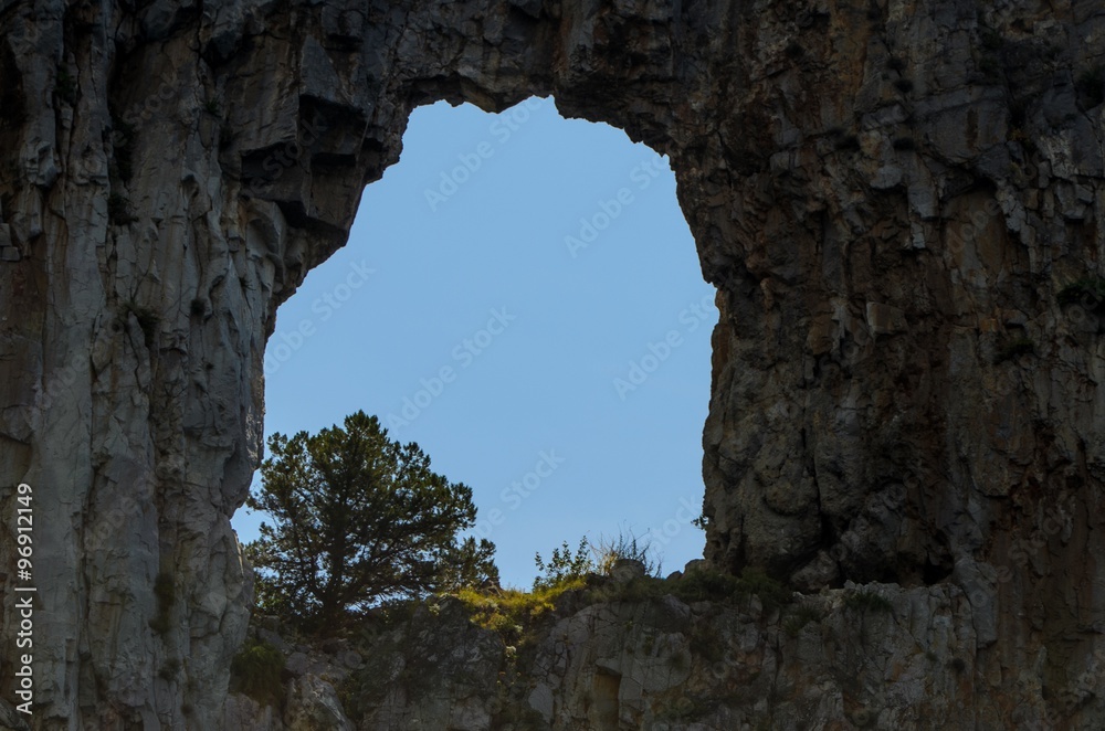 Mountain hole with olive tree inside
