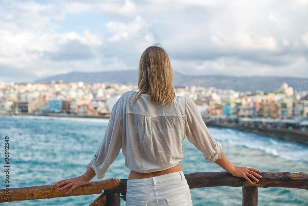 Woman looking at cityscape with bay. From the back. Place for your text. Woman looking at cityscape with bay. From the back. Place for your text.