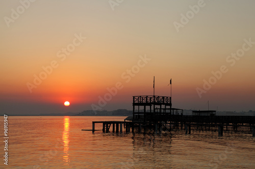 Beautiful sun and the silhouette of wooden platform at sunrise