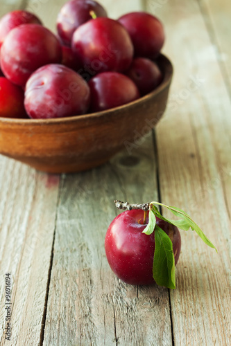 Plums on rustic wooden background