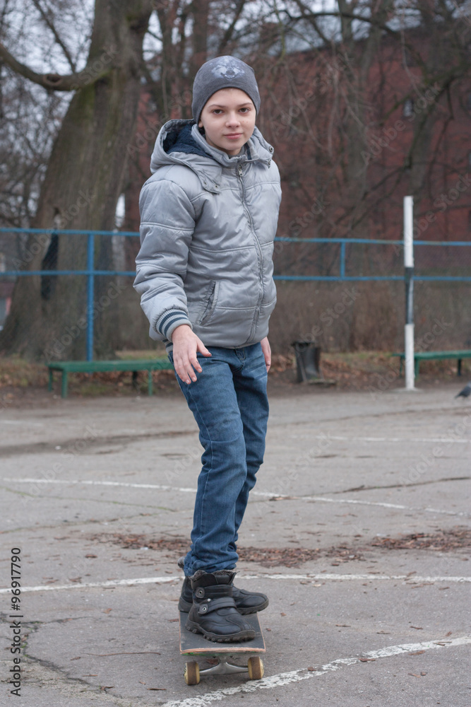 Boy with skate board./Boy with skate board on the street late autumn in cloudy weather. 