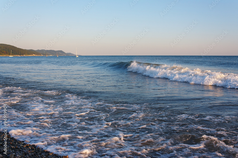 Tranquil surf on the beach against the backdrop of the mountainous coast
