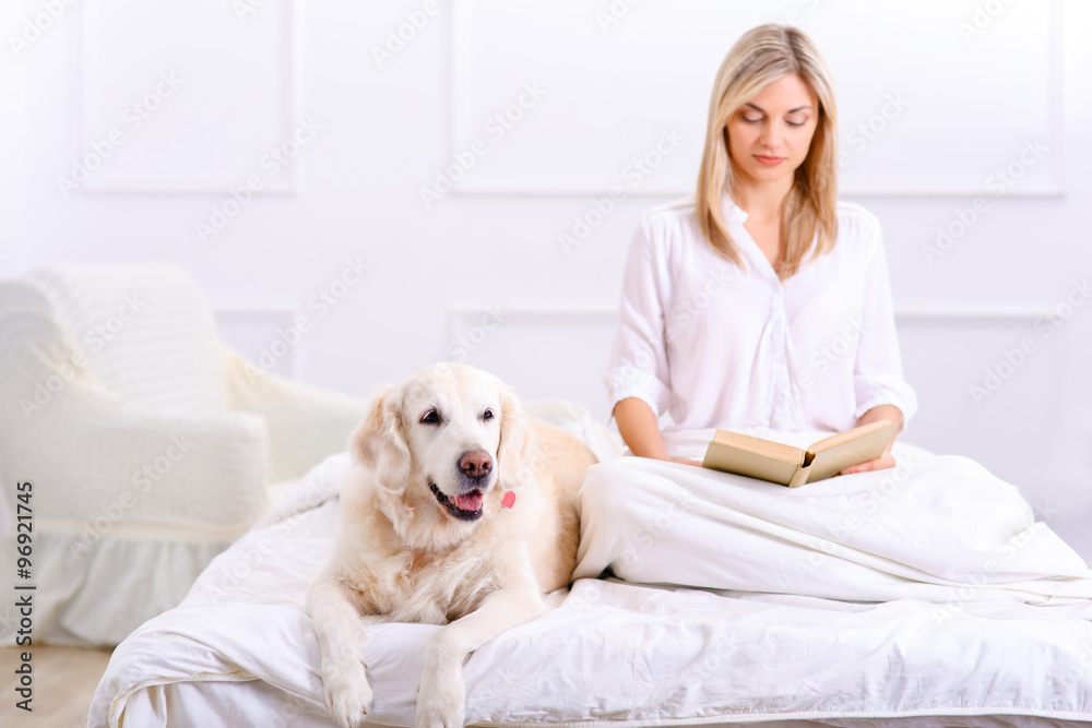 Caring woman lying on bed with her dog Caring woman lying on bed with her dog