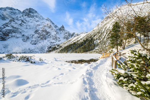 Hiking path in fresh snow along frozen Morskie Oko lake in winter, Tatra Mountains, Poland © pkazmierczak