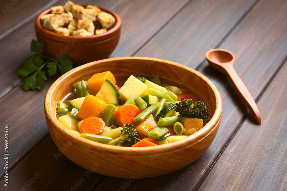 Vegetable soup made of zucchini, green bean, carrot, broccoli, potato and pumpkin, photographed with natural light (Selective Focus, Focus one third into the soup) Vegetable soup made of zucchini, green bean, carrot, broccoli, potato and pumpkin, photographed with natural light (Selective Focus, Focus one third into the soup)