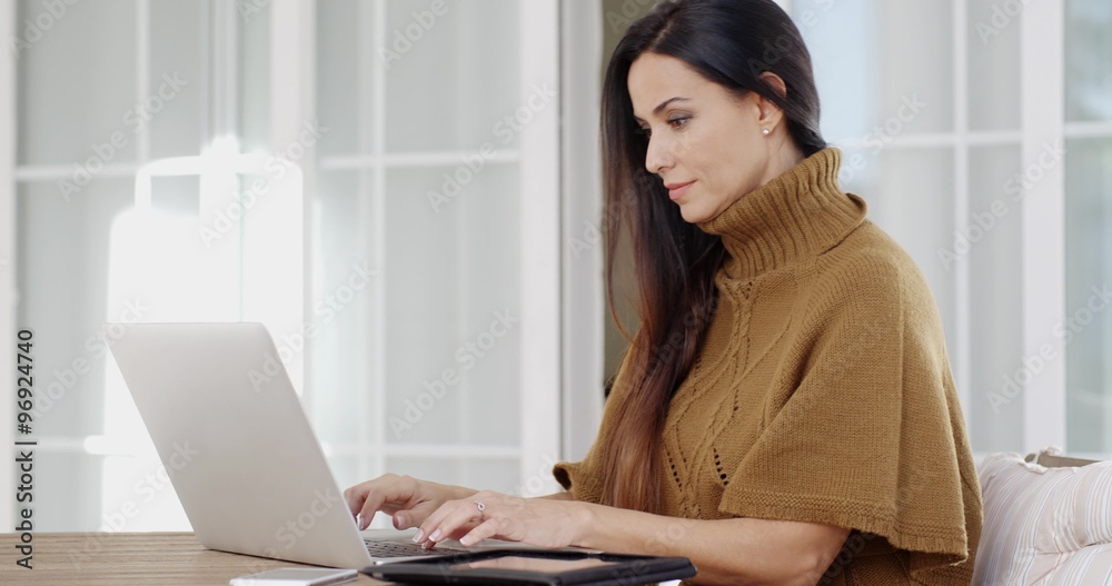 Attractive woman sitting typing on a laptop Attractive woman sitting typing on a laptop