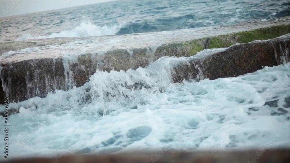 Waves and foam on rocky beach. Breakwater in ocean Waves and foam on rocky beach. Breakwater in ocean