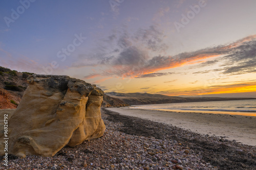 Scenic coastline landscape at sunset with cliff boulders on the