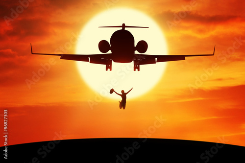 Joyful woman jumping under flying plane