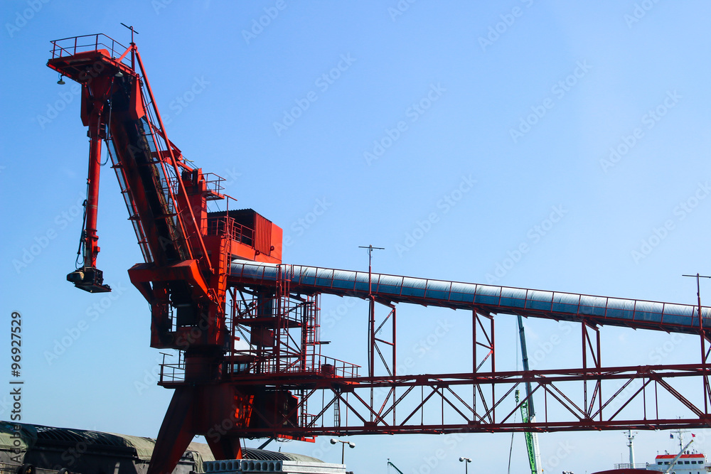 Red machine in atmospheric transport the sugar mill industry outdoor on blue sky background as landscape view Red machine in atmospheric transport the sugar mill industry outdoor on blue sky background as landscape view
