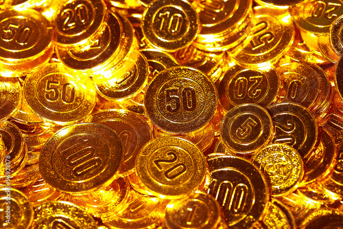 Golden coins piled in a heap of background