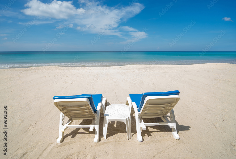 Two beach chairs on the beautiful tropical beach. Back view. Without people Two beach chairs on the beautiful tropical beach. Back view. Without people