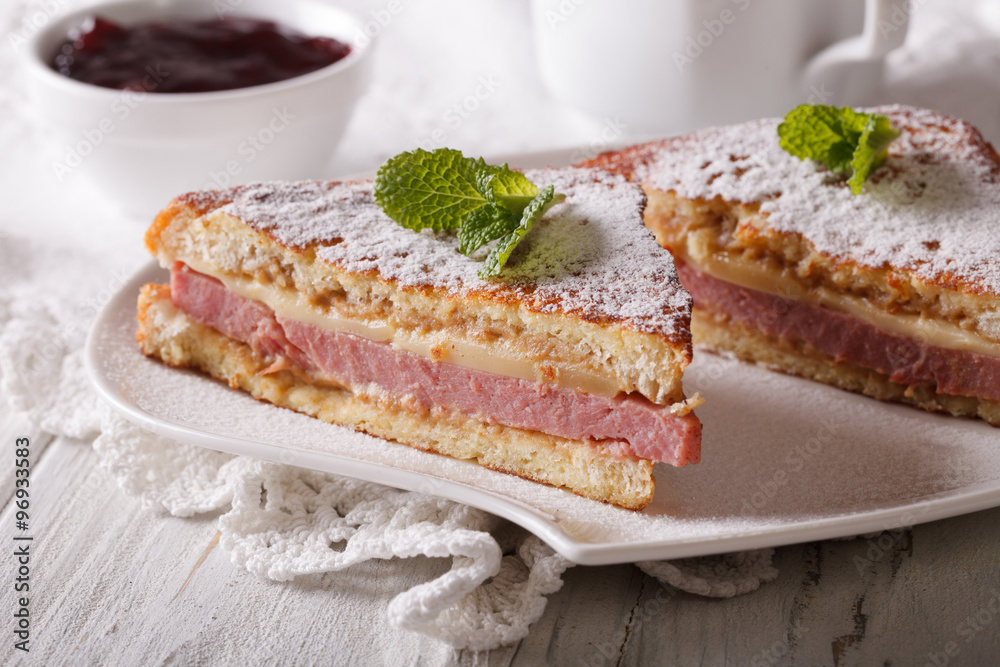 Sandwich of Monte Cristo close-up on a plate and berry jam.
Sandwich of Monte Cristo close-up on a plate and berry jam.