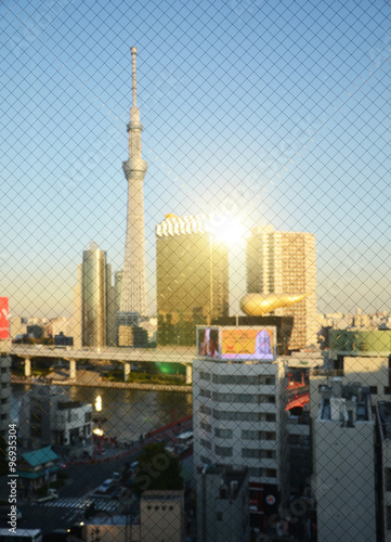 Tokyo Sky tree building at sunset through wired glass. Blurred b
