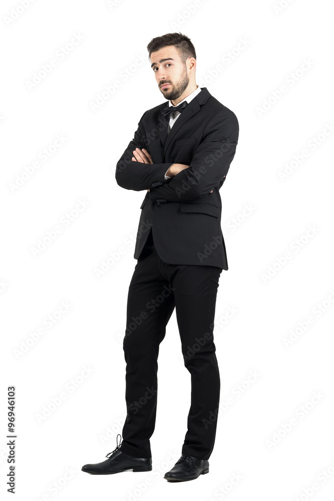 Skeptical defensive man with crossed arms looking at camera suspiciously. Full body length portrait isolated over white studio background. Skeptical defensive man with crossed arms looking at camera suspiciously. Full body length portrait isolated over white studio background.