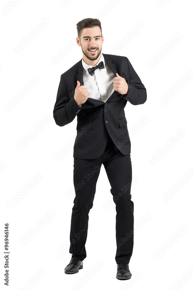 Groom stretching and pulling collar of tuxedo excited look at camera. Full body length portrait isolated over white studio background. Groom stretching and pulling collar of tuxedo excited look at camera. Full body length portrait isolated over white studio background.