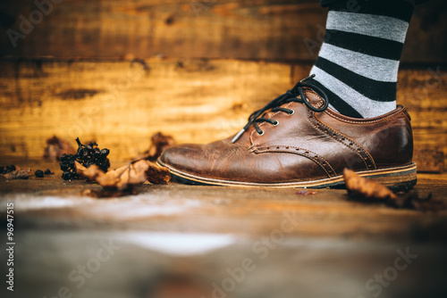 man fashion brown shoes on wood background with striped socks