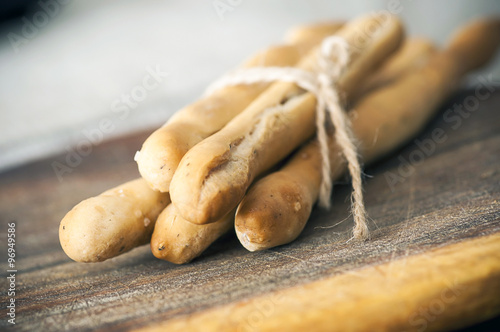 Photos Salted Italian grissini on wooden cutting board close up