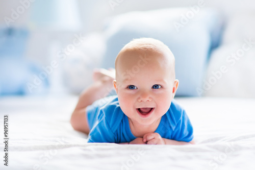 Fototapeta Baby boy in white sunny bedroom