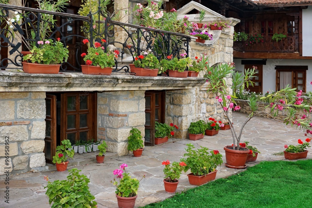 Obraz premium Natural Stone Landscaping In The Backyard With Many Flowerpots