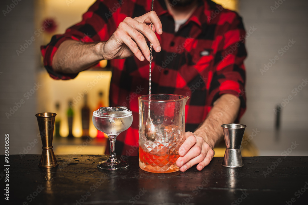 Bartender is stirring cocktails on bar counter