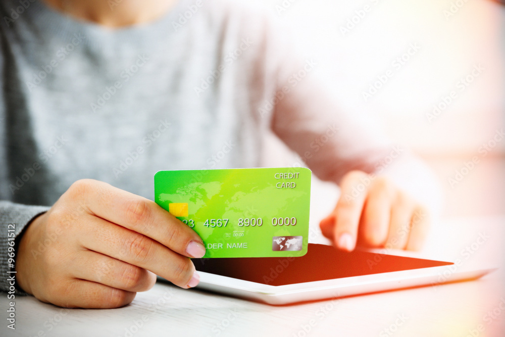 Concept for Internet shopping: hands with digital tablet and credit card Concept for Internet shopping: hands with digital tablet and credit card
