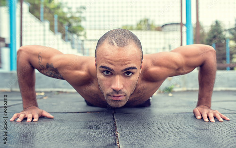 Fototapeta premium athlete doing pull-up on horizontal bar.Mans fitness outdoor
