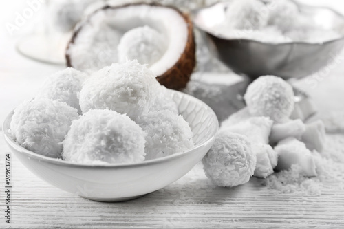 Homemade Candies in coconut flakes and fresh coconut on light background