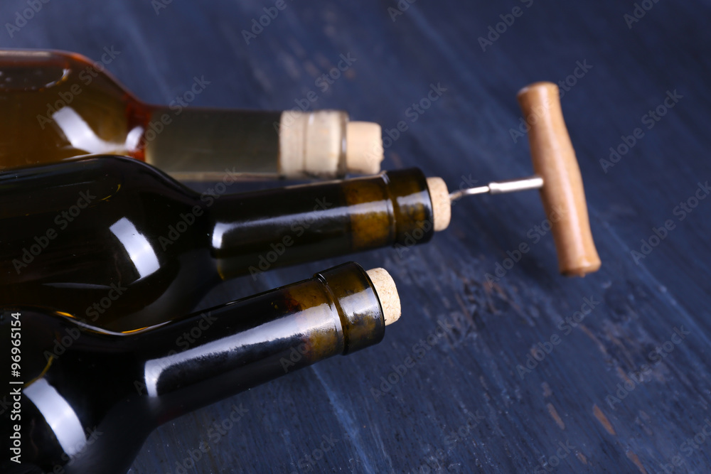 Obraz premium Three bottle wine and corkscrew on blue wooden background