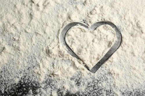 Heart of flour on gray background