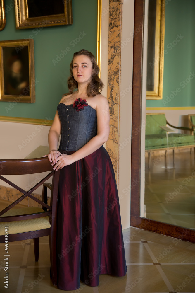 beautiful woman wearing corset posing in  palace