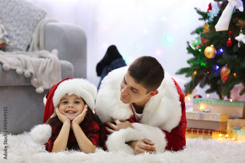 Obraz premium Happy father and daughter on the floor in the decorated Christmas room