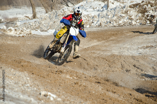 The rider on a motorcycle on the background of the snow drifts