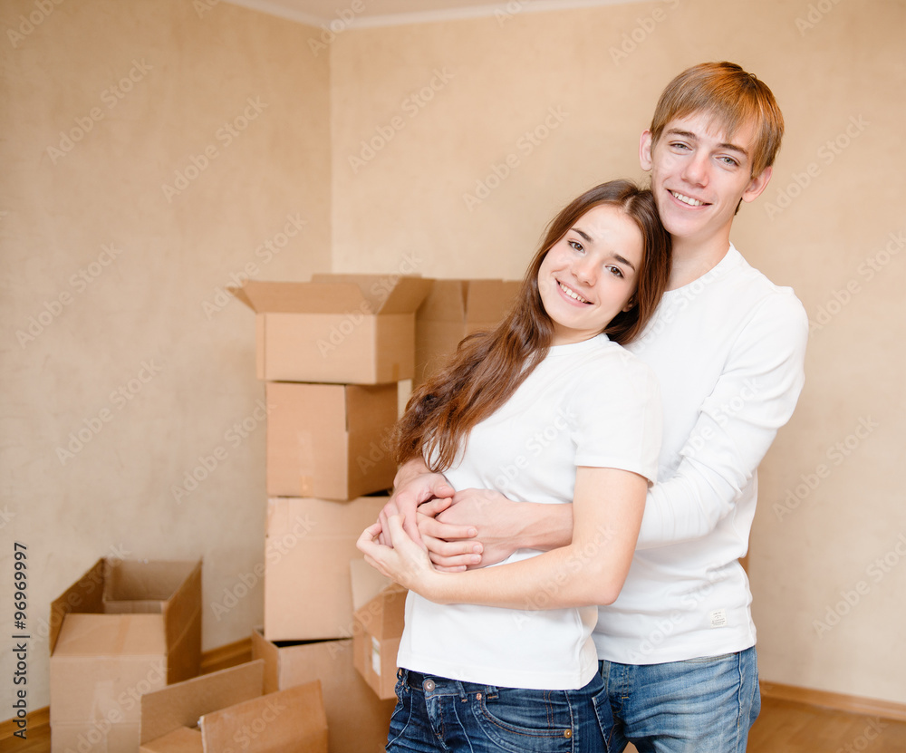 happy young family hugging on a background of cardboard boxes happy young family hugging on a background of cardboard boxes